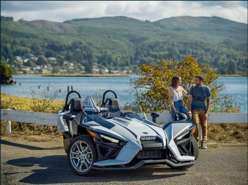 couple by river with slingshot vehicle