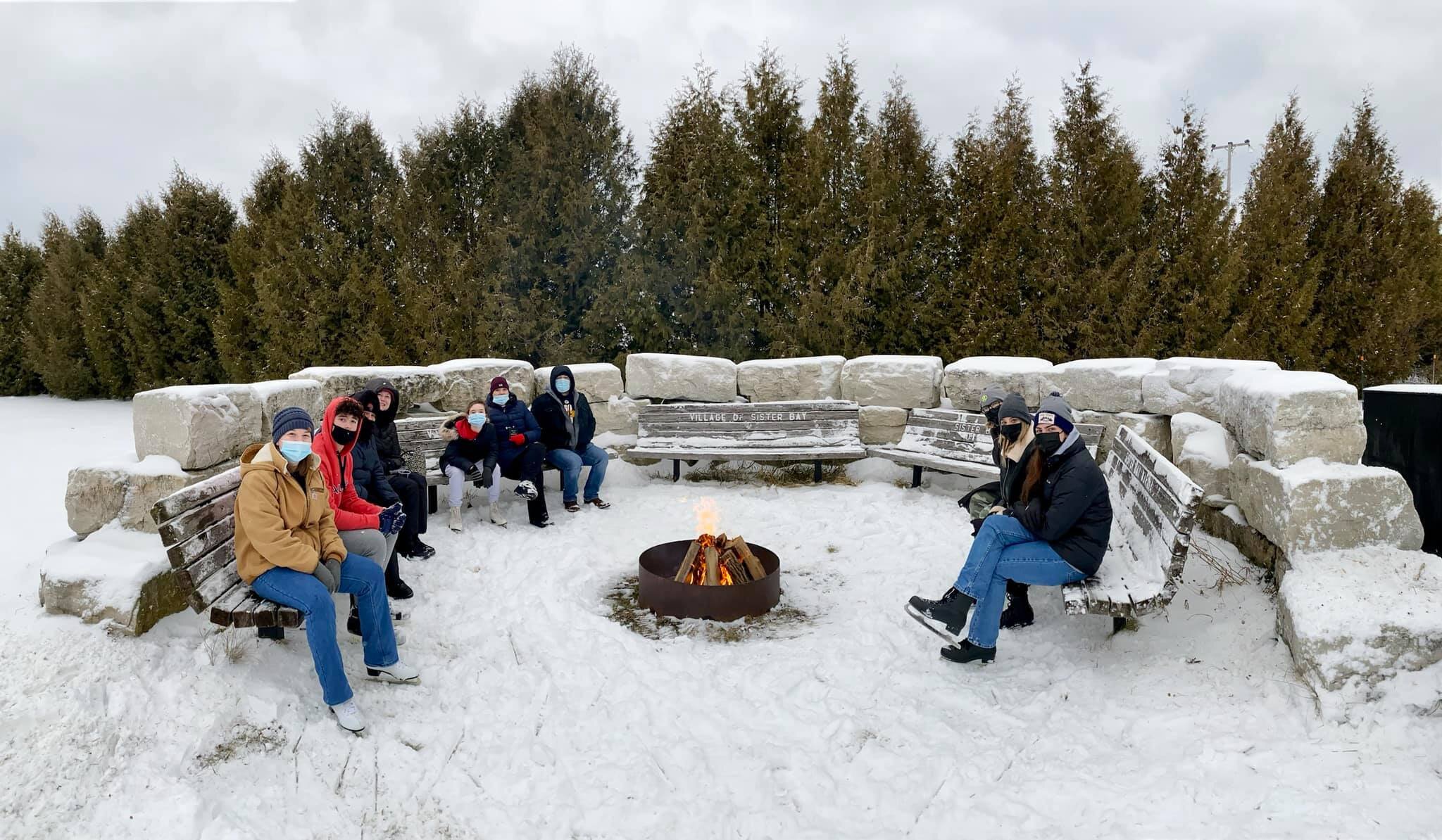 people around a campfire in the snow