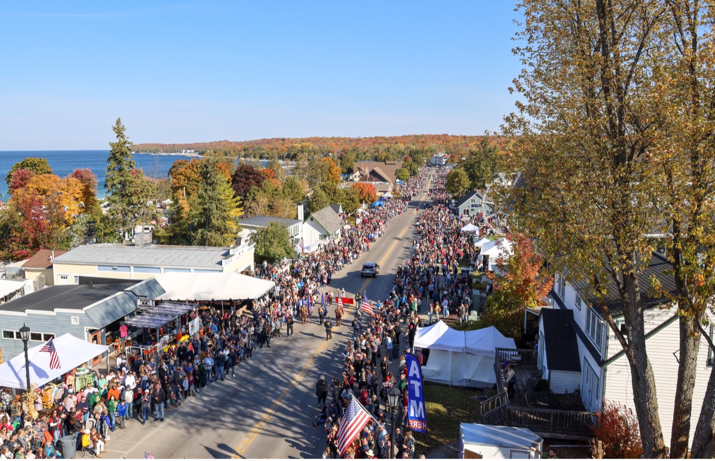 Crowd gathering for fall fest parade with beautiful fall colors and water in background