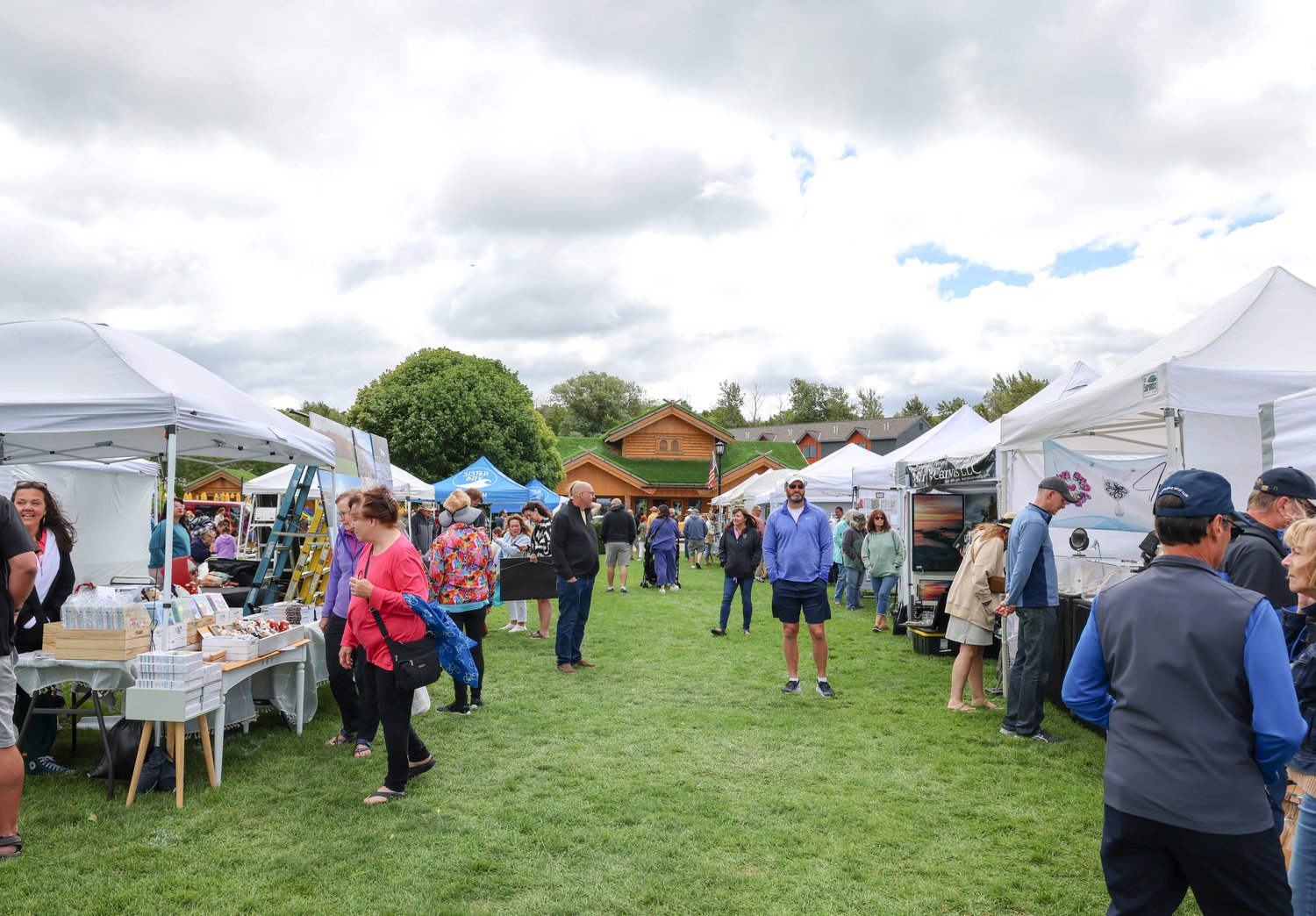 People walking around the vendors booths at Door County Festival of Fine Arts logo