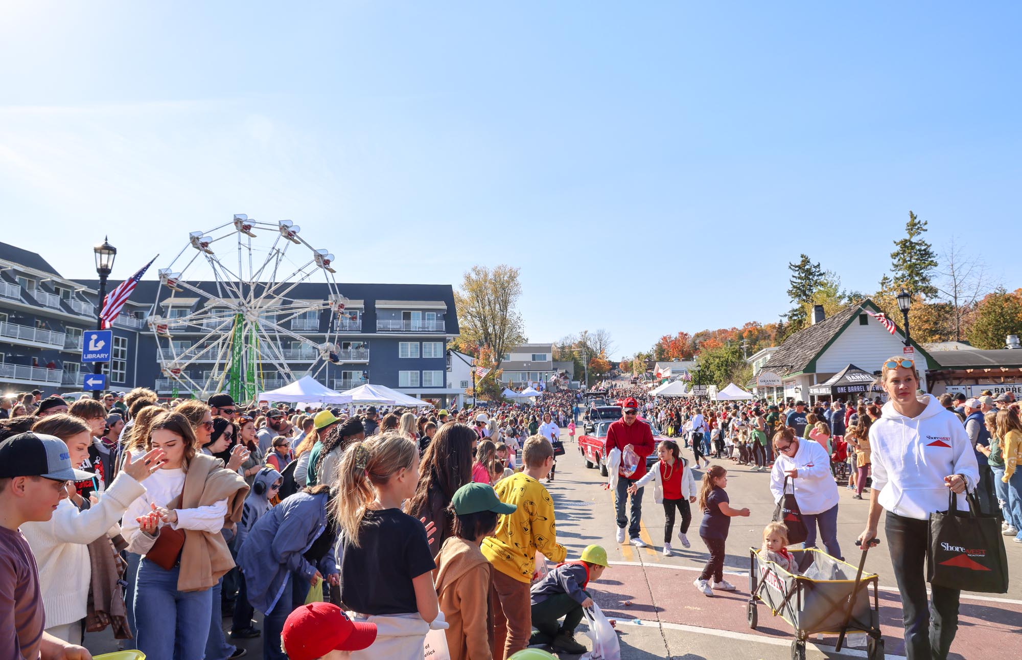 A busy fall fest with carnicial rides in the distance
