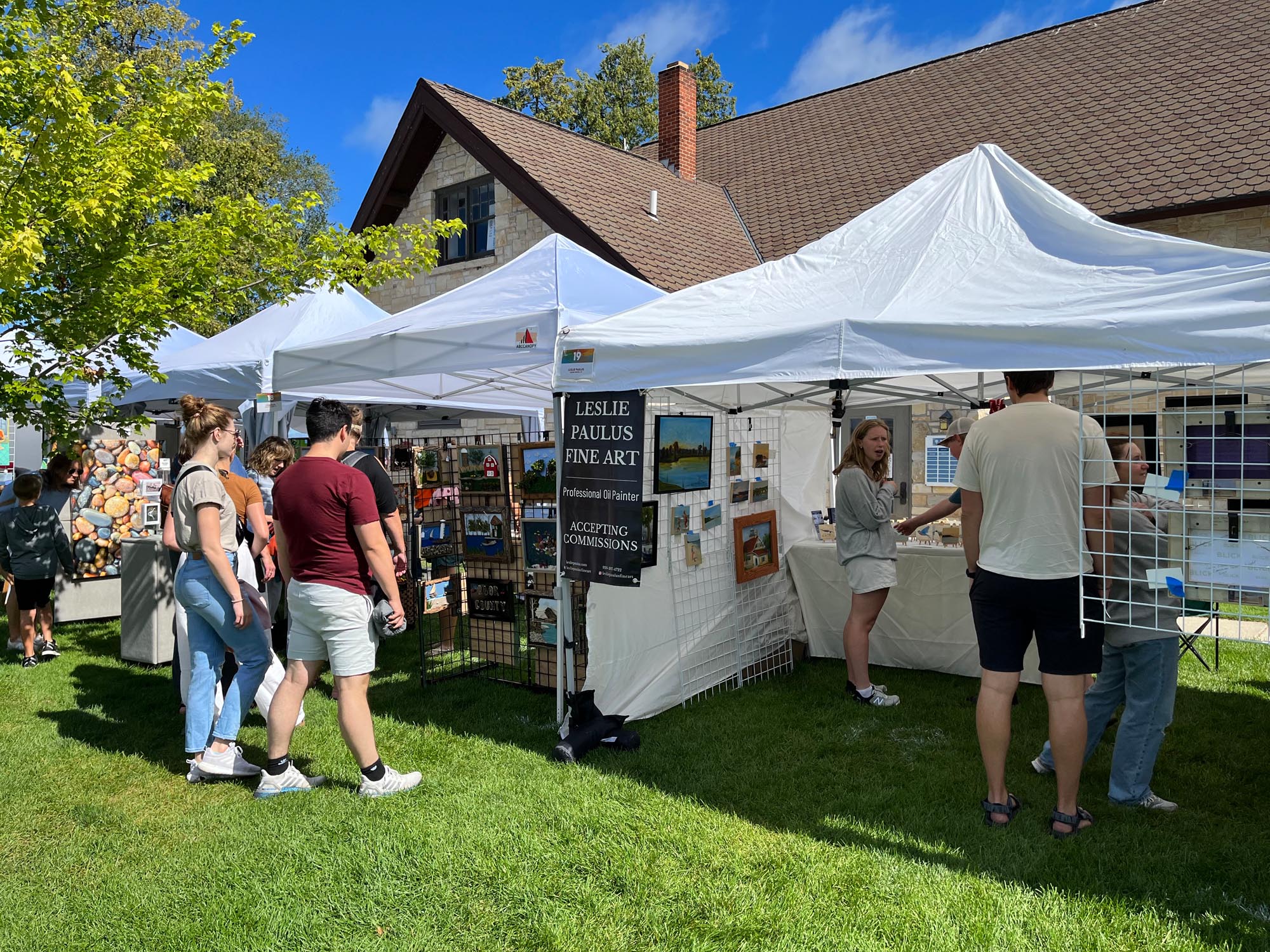 People checking out a oil painters tent