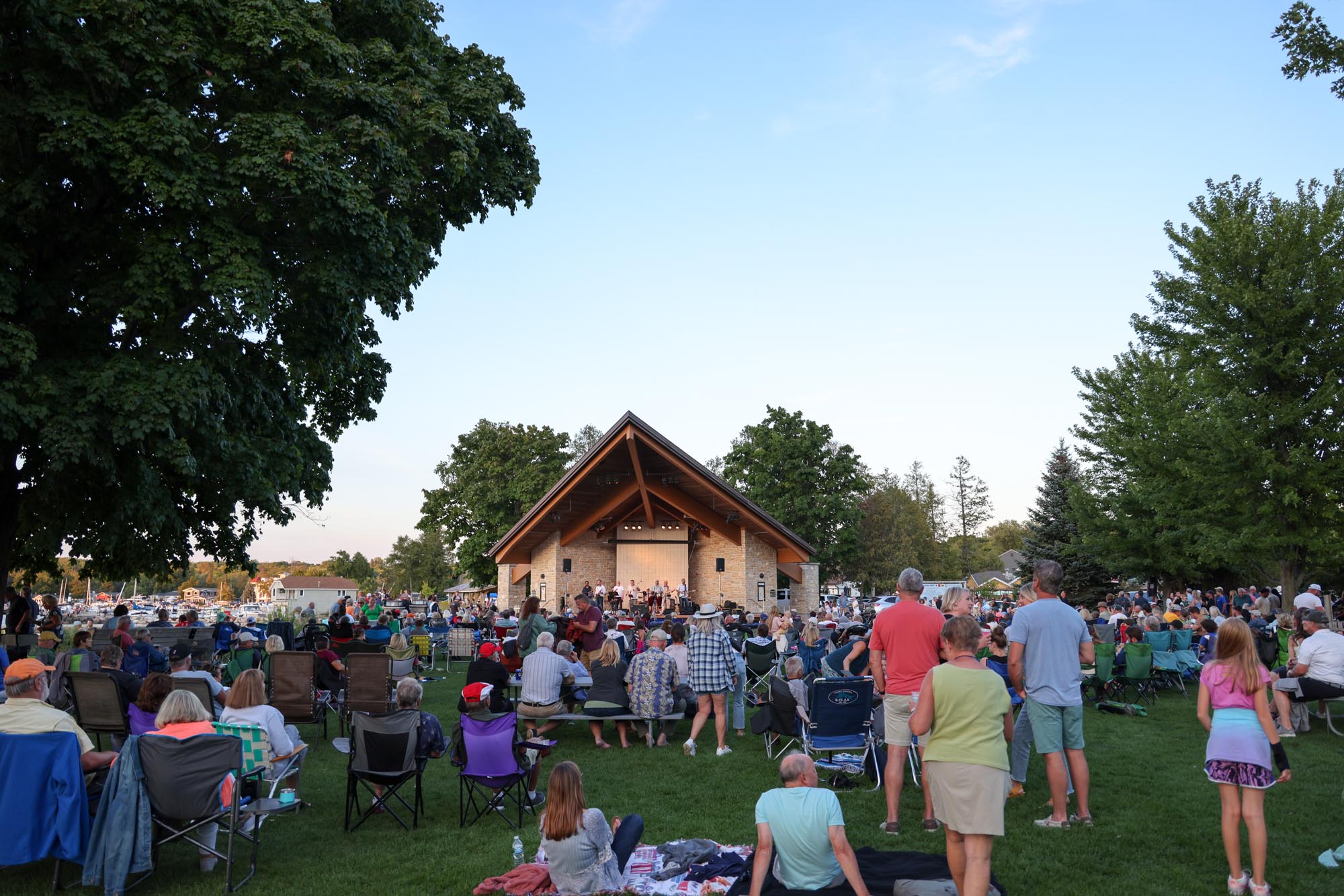 People watching a band perform in the park.