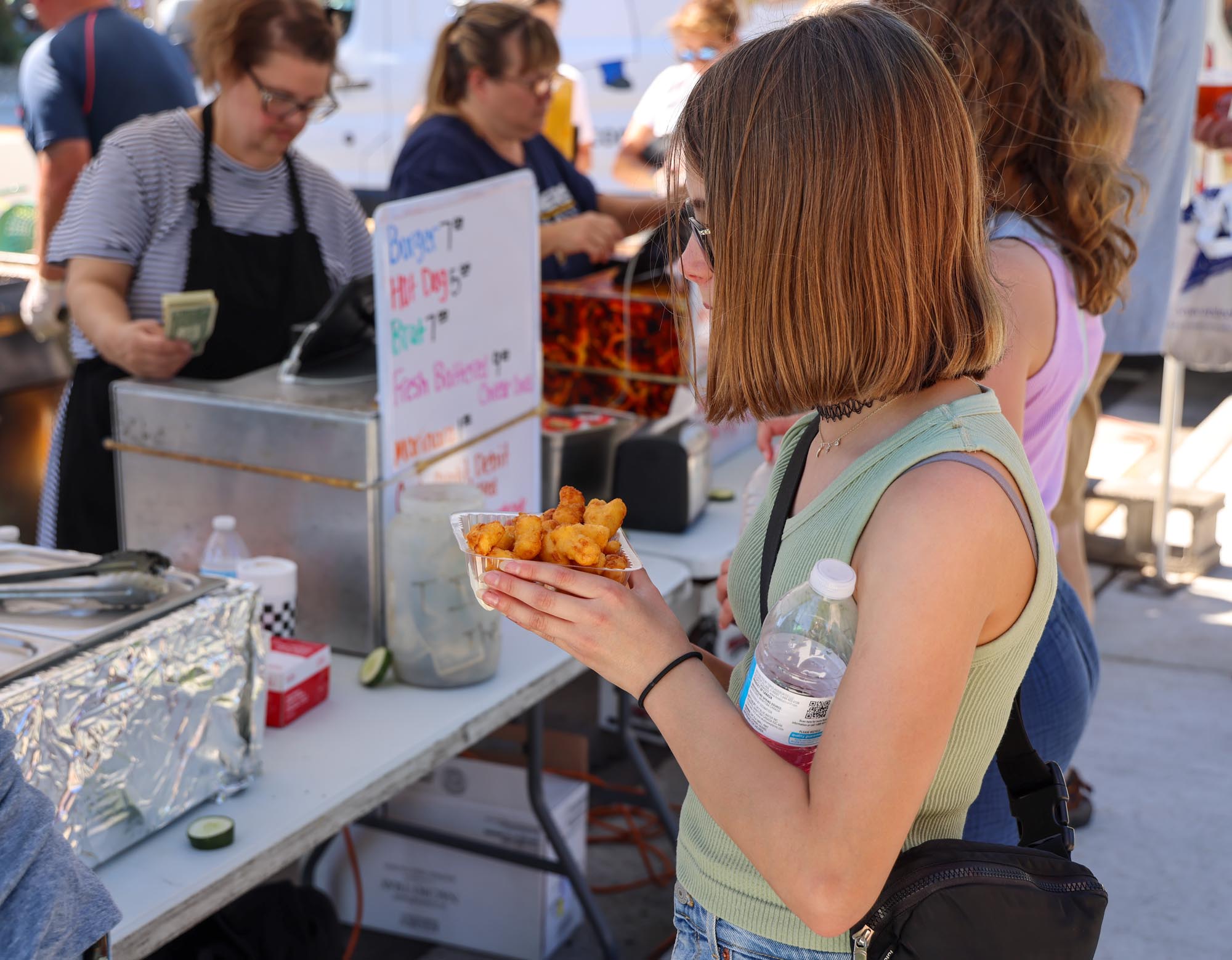 A little girl snacking on cheese curds