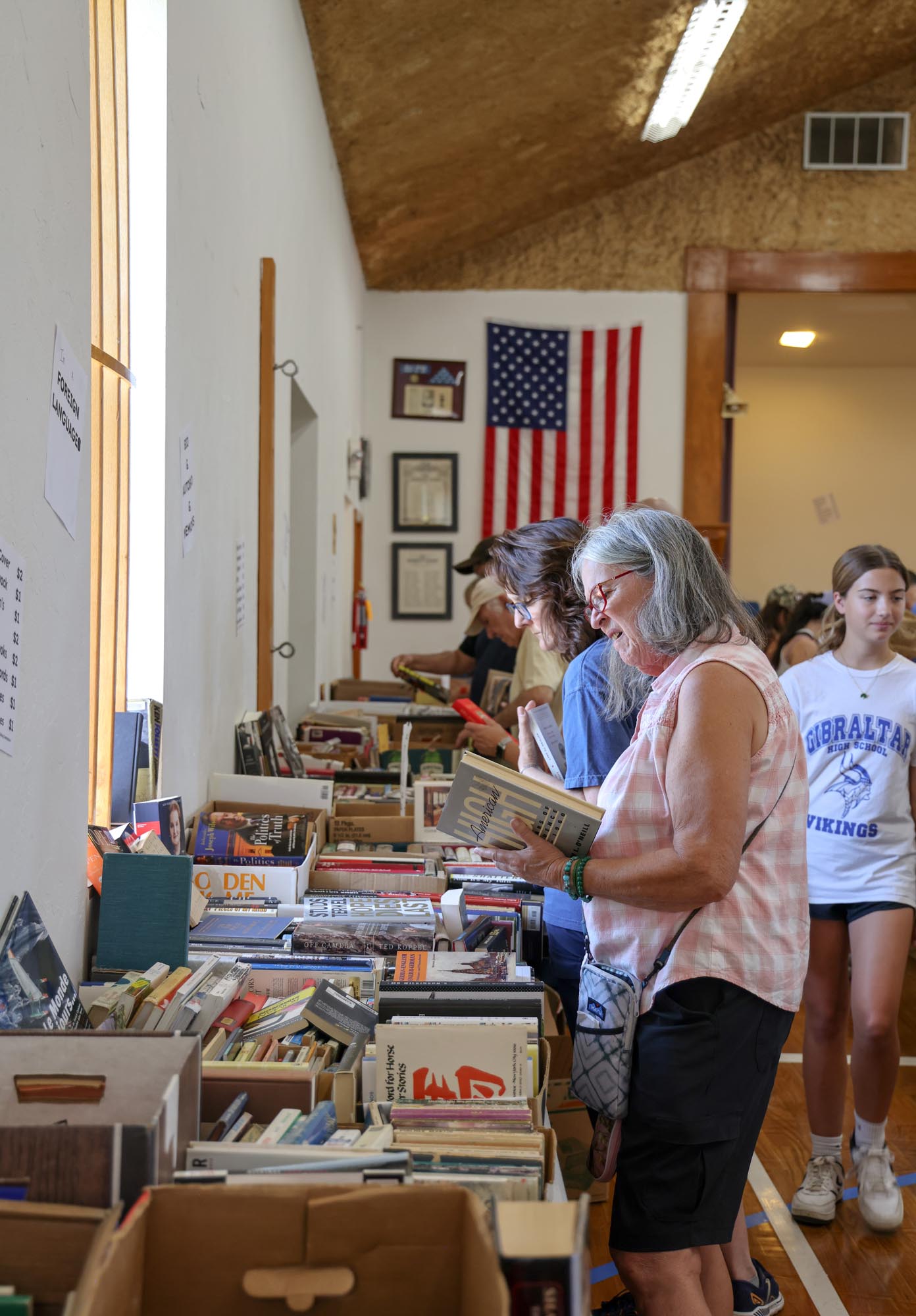 a women shopping and looking at a book.