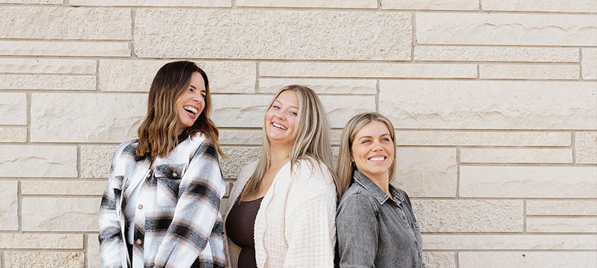 Three women posing with purses from Spot in Sister Bay