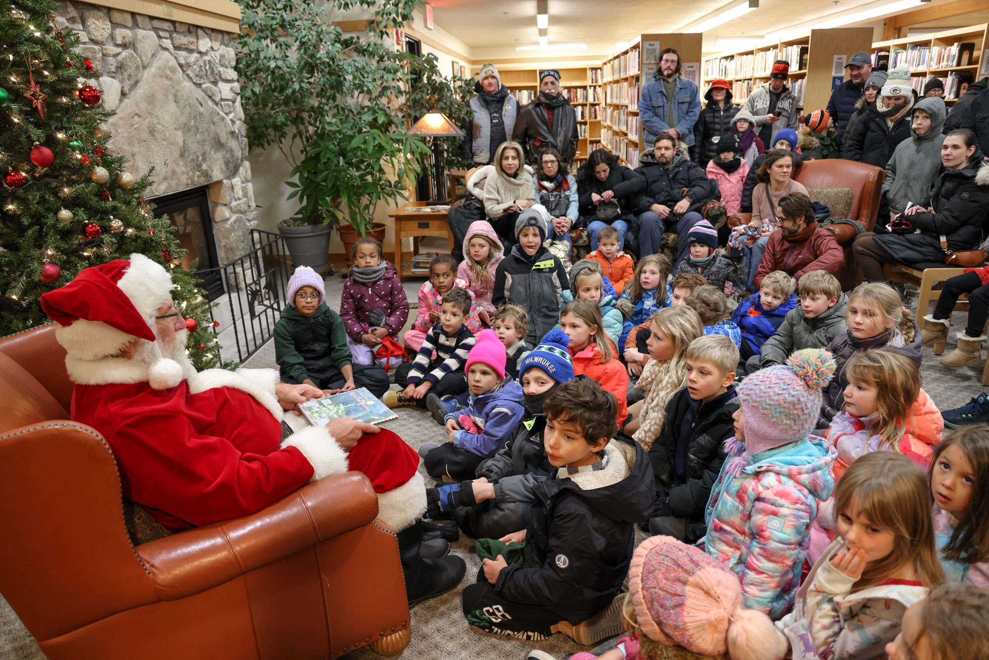 Santa reading a story to little boys and girls