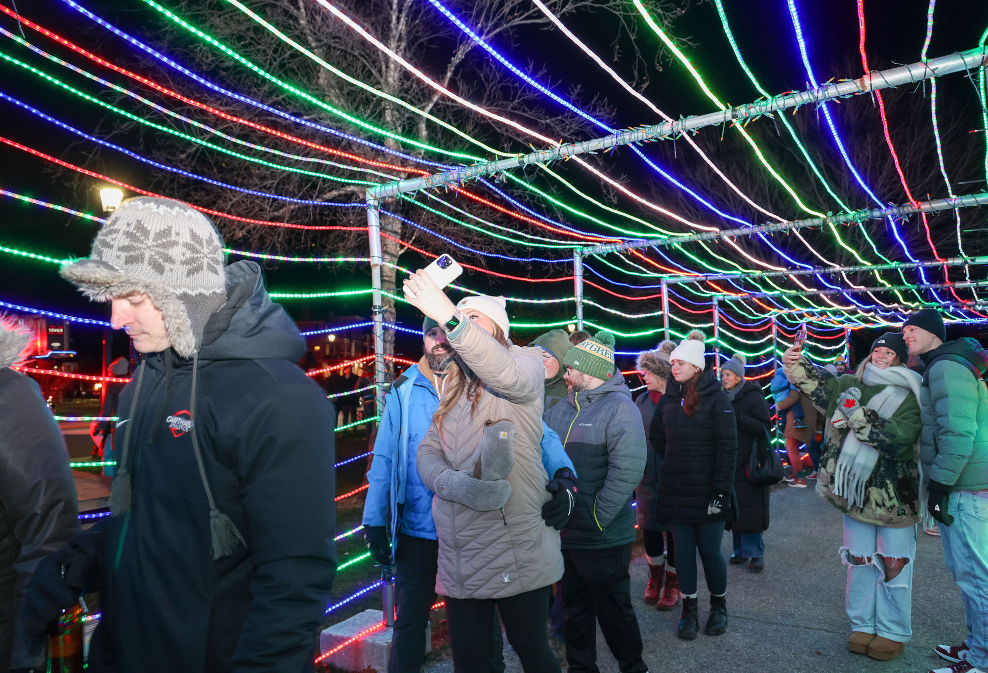 People walking under a light tunnel