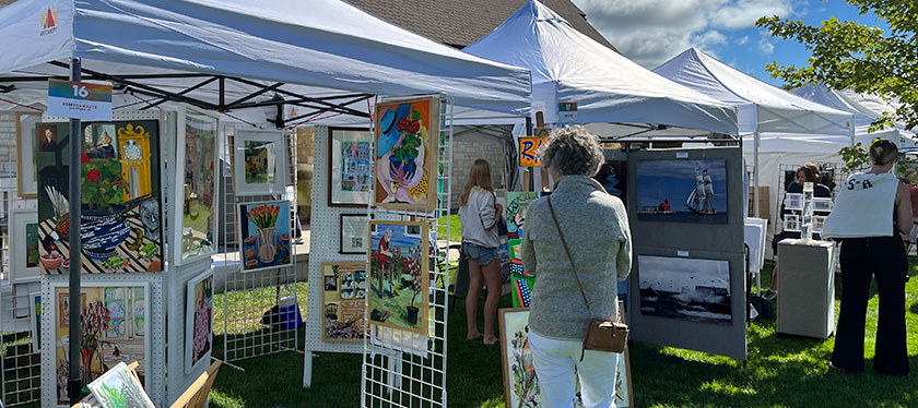 A women perusing some tents full of art