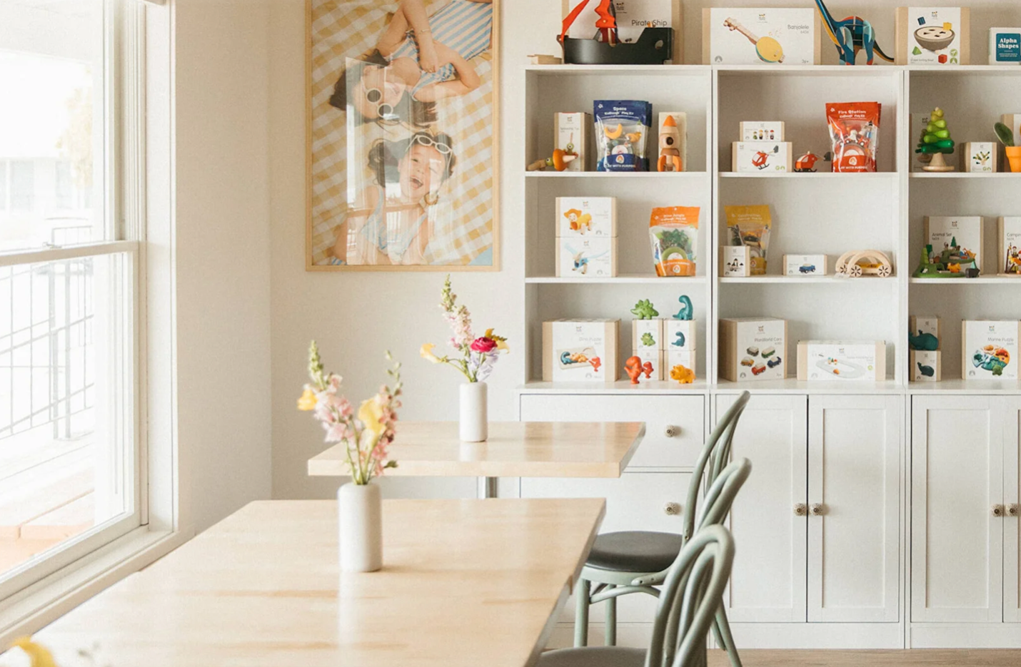 Bright coffee shop with color flowers on the tables and colorful gifts on the shelf