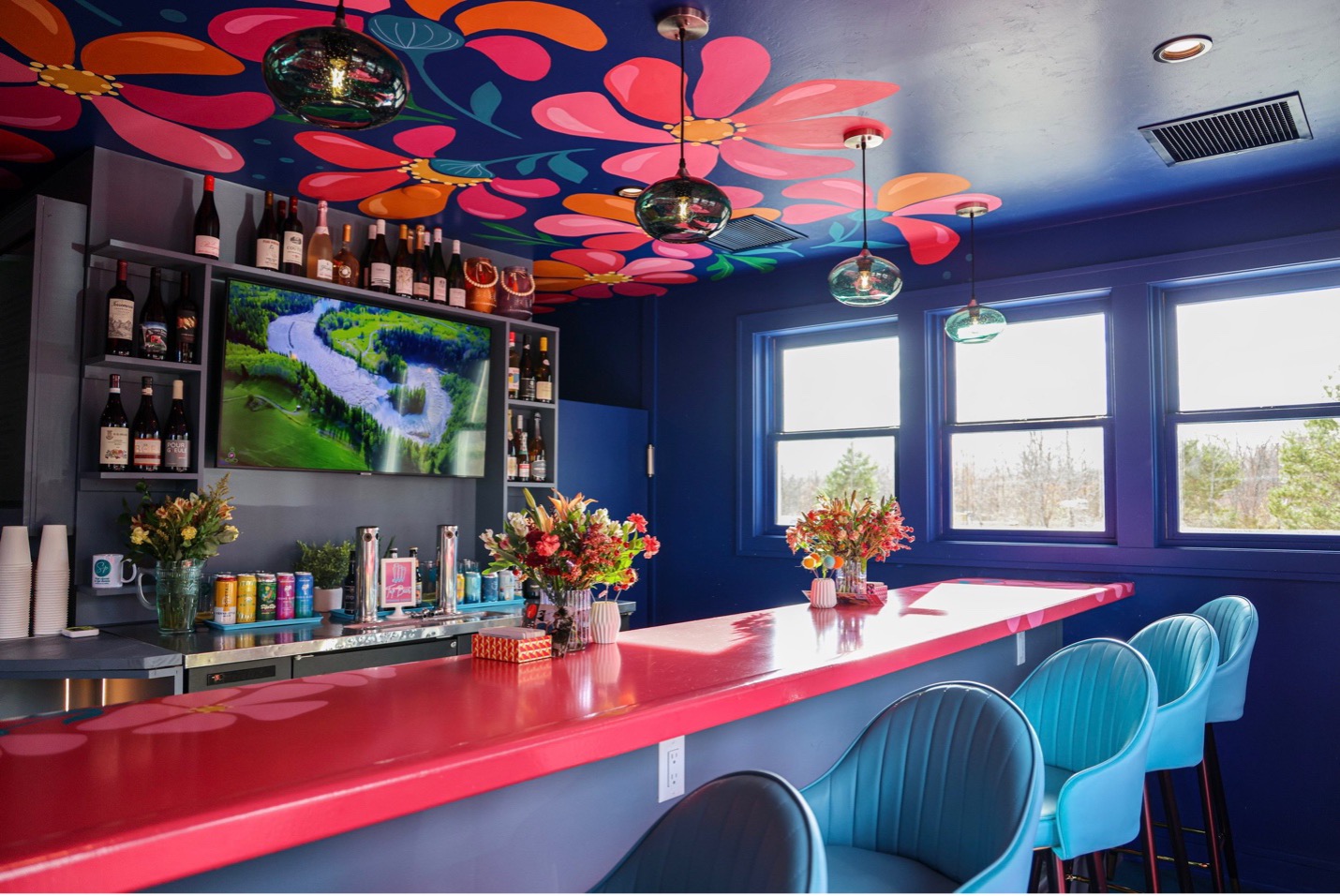 Coffee shop with vibrant blue walls and bright pink decor and accents